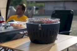 LotusGrill XL Hybrid Houtskoolbarbecue - Rood -Sport Buitenkamperen lotusgrill in gebruik met toppy shirtje 2