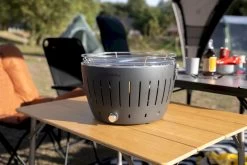 LotusGrill XL Hybrid Houtskoolbarbecue - Rood -Sport Buitenkamperen lotusgrill in zon op tafel 3